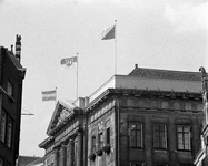 855219 Gezicht op de bovengevel van het Stadhuis (Stadhuisbrug 1), waar de vlaggen van Utrecht en Hannover wapperen, ...
